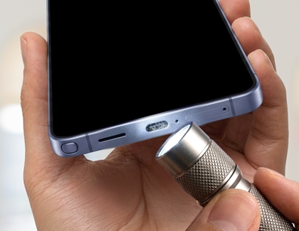 Inspecting the charging port with a flashlight.