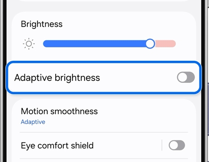 A Galaxy phone screen showing display settings with the disabled Adaptive brightness option highlighted.