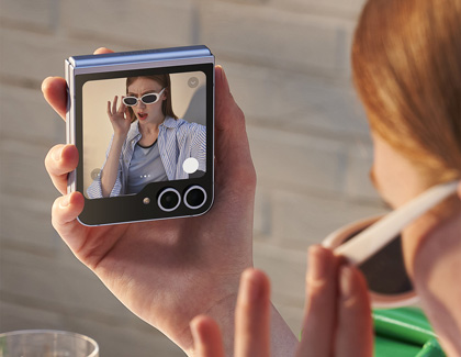 A girl taking a selfie using the cover screen of a Galaxy Z Flip6