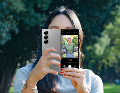 A person taking a picture on a Galaxy Z Fold6 while using the cover screen preview feature.