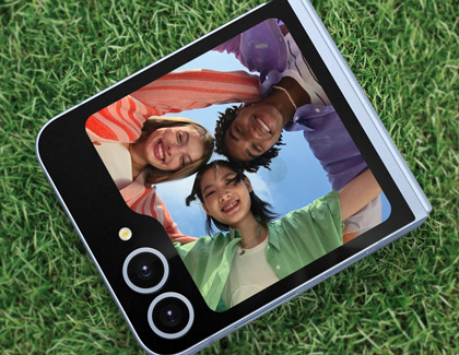 Galaxy Z Flip6 placed on the ground while using the cover screen to take a picture of a group of people