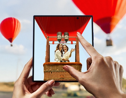 A person zooming in on a hot air balloon photo using the unfolded Galaxy Z Fold7.