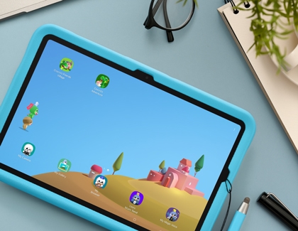 A blue Galaxy kids edition tablet showing the Samsung Kids home screen with various app icons.