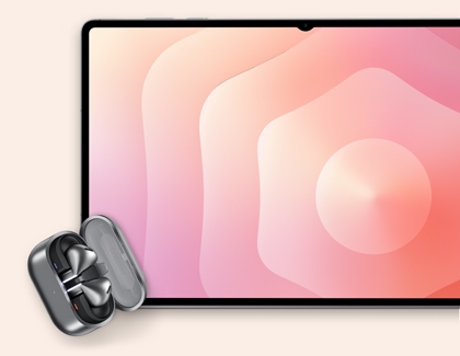 Galaxy Buds resting in an open charging case next to a Galaxy Tab S11 Ultra.