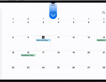 A Galaxy tablet screen showing a calendar with a blue arrow pointing down from the top center.