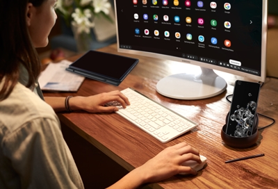 Woman using Samsung Dex on a connected phone with Tab S6 on the table