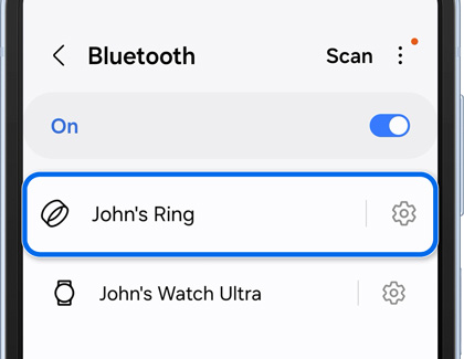 A smartphone screen displaying Bluetooth settings with multiple connected devices including 'John's Ring,' with a charging case for the ring in the background.