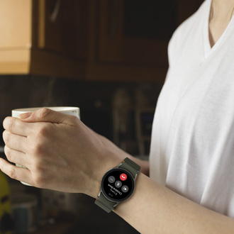 Person holding a cup while making a phone call with a Galaxy Watch