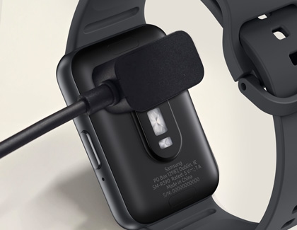 Back view of a Galaxy Fit3 with a charging cable magnetically connected.