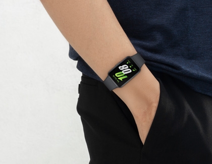 Person wearing the Galaxy Fit3 on their wrist, displaying the digital screen with fitness stats.