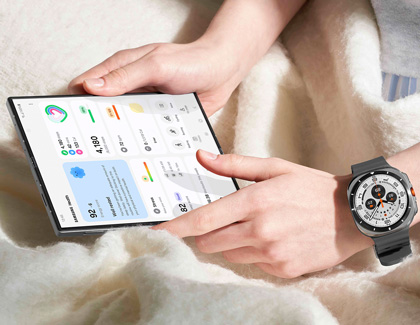 A person sitting with a tablet displaying health tracking information, while wearing a Galaxy Watch7 on their wrist.