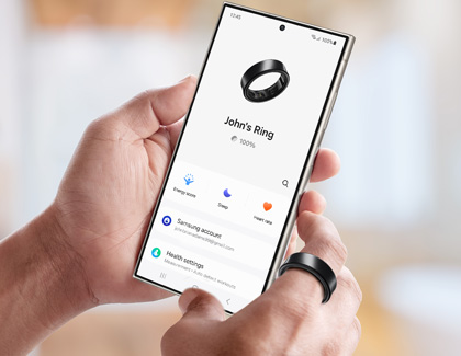  Hand holding a Galaxy S24 Ultra with the Galaxy Wearable app open, while wearing a Galaxy Ring