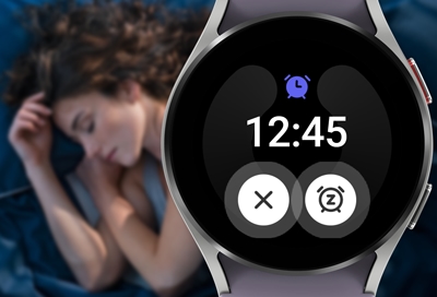 Woman sleeping with a Galaxy watch5 showing alarm