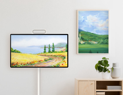 MovingStyle displaying a landscape painting next to a similar framed painting on a white wall.