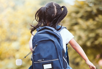 Girl skipping with SmartThings Tracker on her backpack