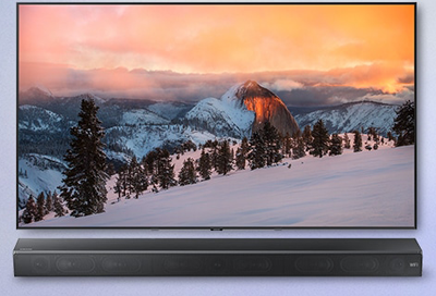 A Samsung TV depicting a snowy mountain scene, with a Soundbar below