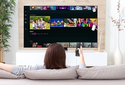 Woman sitting in front a wall-mounted Samsung TV 
