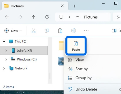 Windows File Explorer window showing the Paste option highlighted to copy files to the connected device.