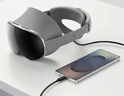 Galaxy XR headset connected to a Galaxy phone with a USB cable on a table.