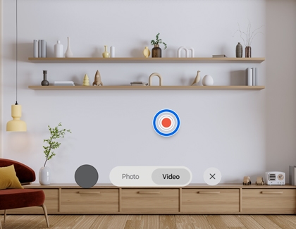 Samsung XR interface with the Record icon highlighted in Video mode over a living room scene.