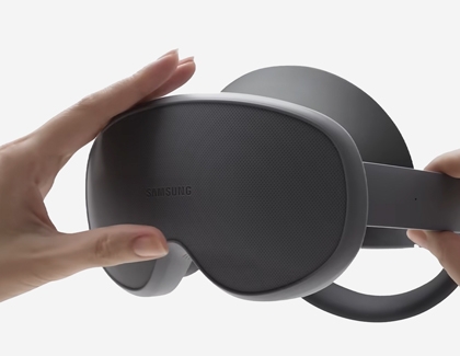 Hands pressing the edge of the protective front cover of the Galaxy XR headset.