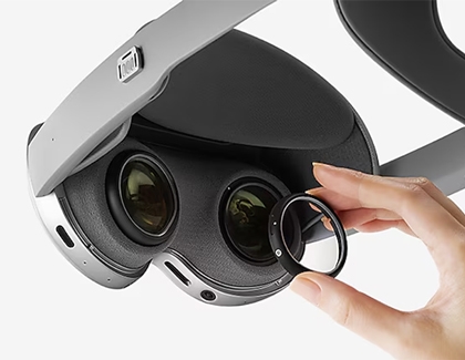 Hand holding a lens insert and aligning it above the lens mount inside the Galaxy XR headset.