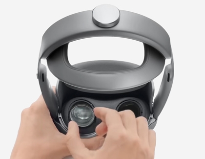 Hands pressing a lens insert into place inside the Galaxy XR headset.