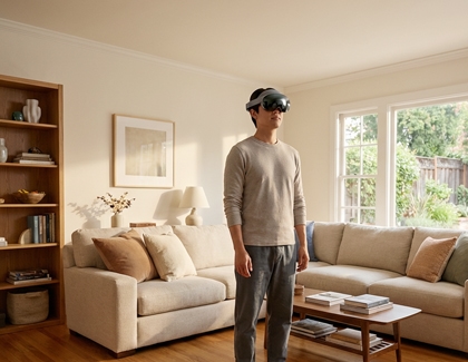 A person wearing the Galaxy XR headset and standing upright in a living room.