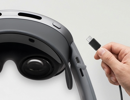 Hand holding a USB-C cable near the USB-C port on the Galaxy XR headset.