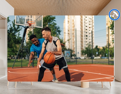 Large immersive screen showing two people playing basketball on an outdoor court, with the spatial audio icon highlighted.