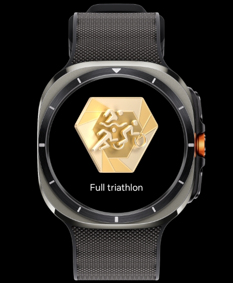 A Galaxy Watch Ultra displaying a milestone badge and a text of 'Full triathlon'.