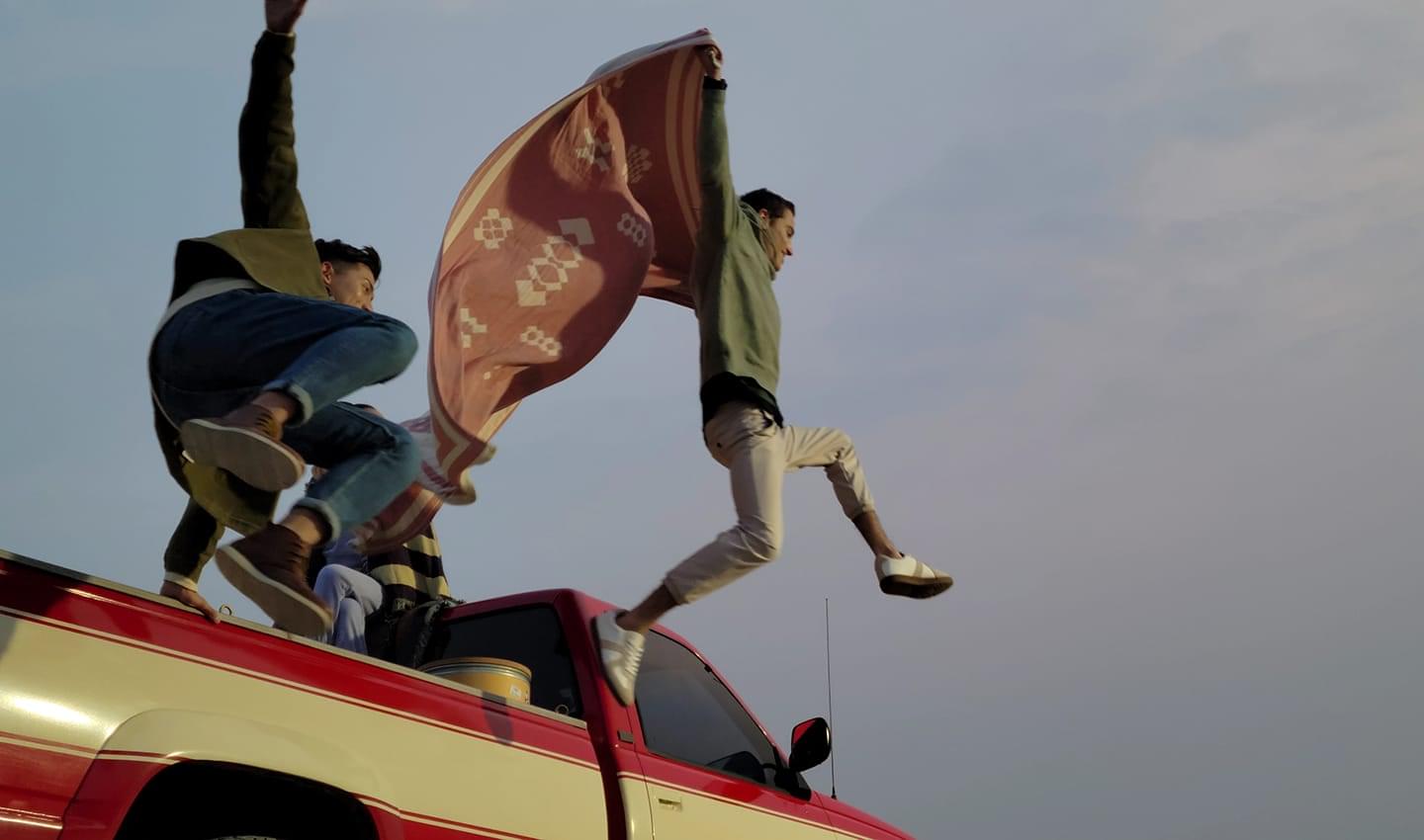 Three friends riding in a pickup truck, with two jumping out of the back. Scene shot with 8K video mode, and one still cut captured with 8K Video Snap.