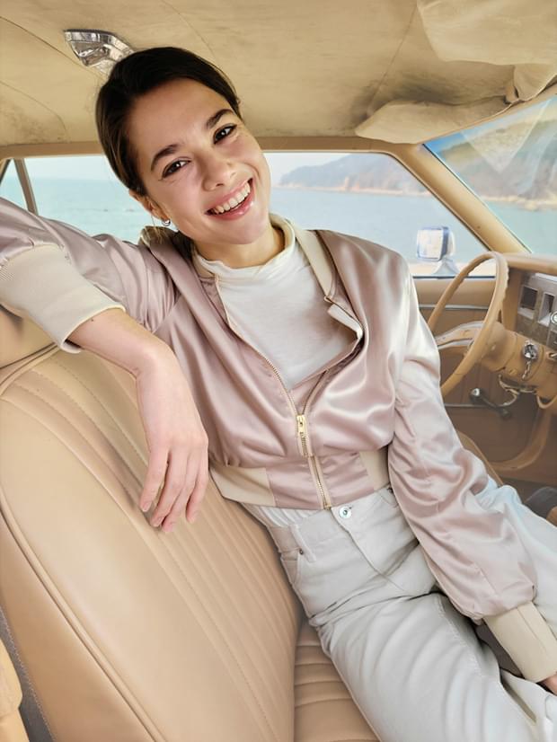 Woman sitting in the driver's seat, taken in Portrait Mode with Backdrop effect applied.