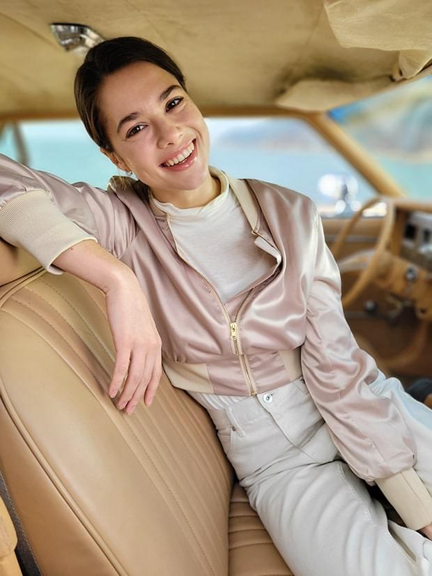 Woman sitting in the driver's seat, taken in Portrait Mode with Studio effect applied.