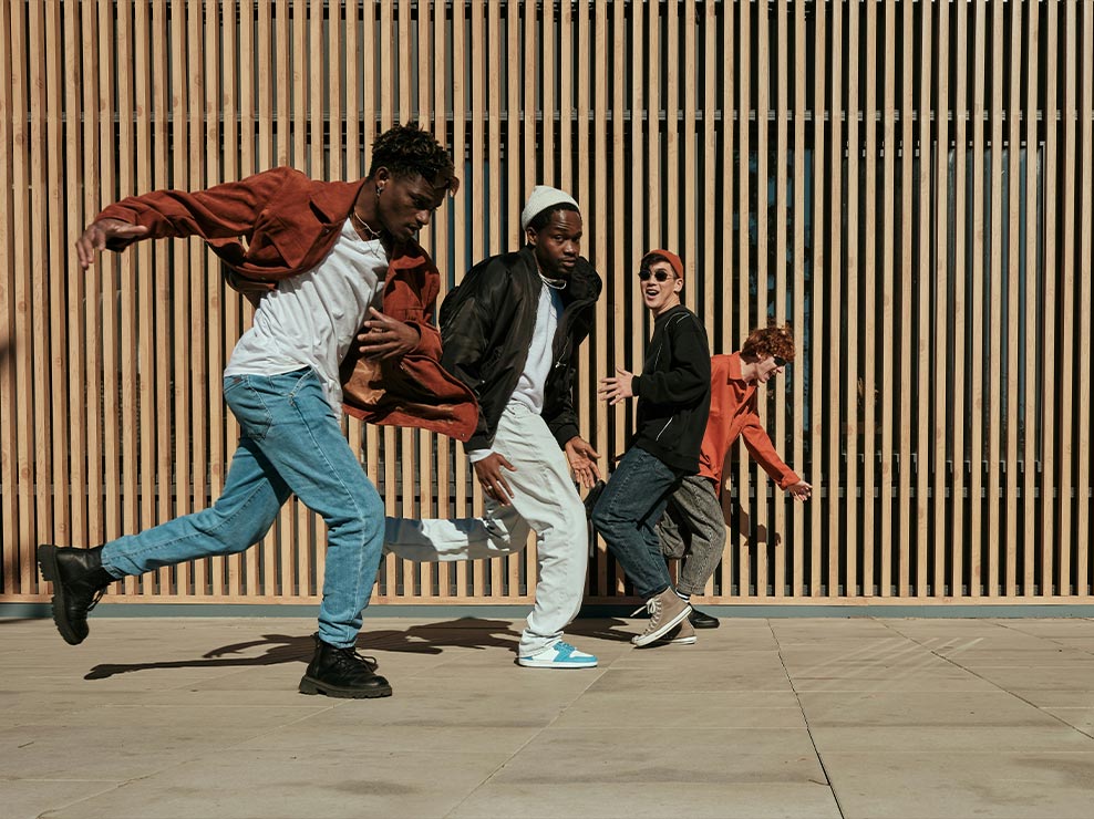 A photo of four men running in front of a wood-panel wall is clear, vibrant and full of detail.