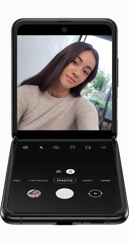 Galaxy Z Flip folded at a right angle with the Camera app onscreen showing how Flex UX puts the control on the lower half of the screen