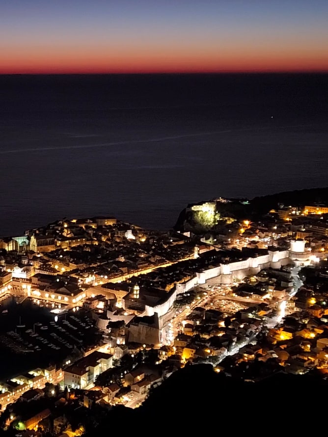 Night Hyperlapse video of an aerial view of a city at night
									with buildings lit up and car headlights becoming light trails as they move