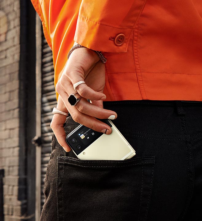 The man's hand, pushing Galaxy Z Flip3 5G into the back pocket of his jeans.