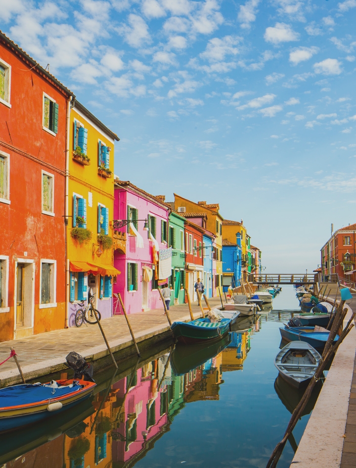 Interactive image of a canal and gondolas with a row of colorfull houses on either side.